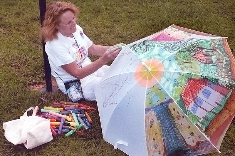 woman sitting on lawn working with umbrella